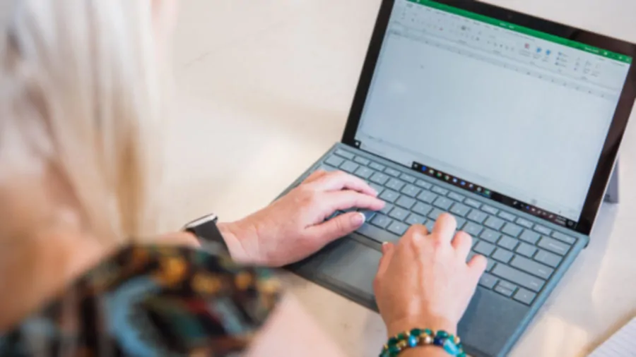 Woman typing on a laptop.